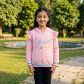 Pink hooded girls sweatshirt with frilled shoulders and glitter lining at the sleeves and bottom ends. The shirt has a sports logo on the front.