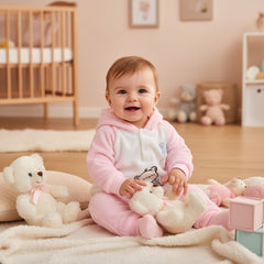 A two-piece baby outfit with a hoodie and pants, featuring a star and a bear illustration, in a pink color.