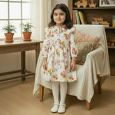 A floral print baby frock with a pleated ban neck and ruffle detailing.