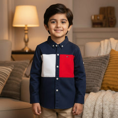 Young boy wearing a navy shirt with red and white patches