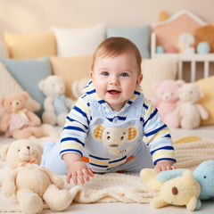 A baby in a blue hooded button down shirt and matching dungarees with a striped pattern and a tiger design on the front.