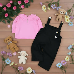 Pink shirt and black overalls.