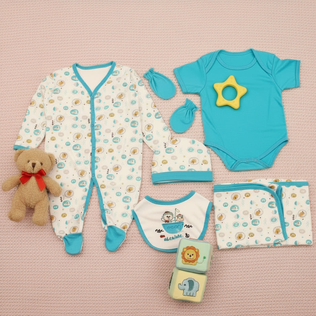 A set of baby boy clothing and accessories including a bodysuit, romper, bib, cap, and mittens, laid out on a wooden surface. The clothing is primarily blue with a pattern of sea creatures and plants.