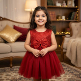 Young girl in a red dress standing in a cozy living room.