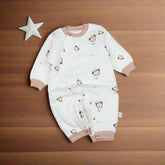 A white baby romper with teddy bear face patterns and a pink trim.