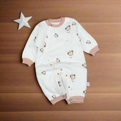 A white baby romper with teddy bear face patterns and a pink trim.