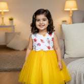 Yellow dress with a white top featuring colorful patterns.