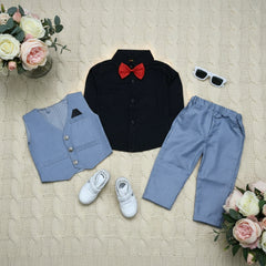 Children's formal outfit with black shirt, red bow tie, blue pants, vest, white shoes, and sunglasses on a wooden surface.