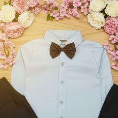 Light blue dress shirt with a black bow tie on a wooden surface