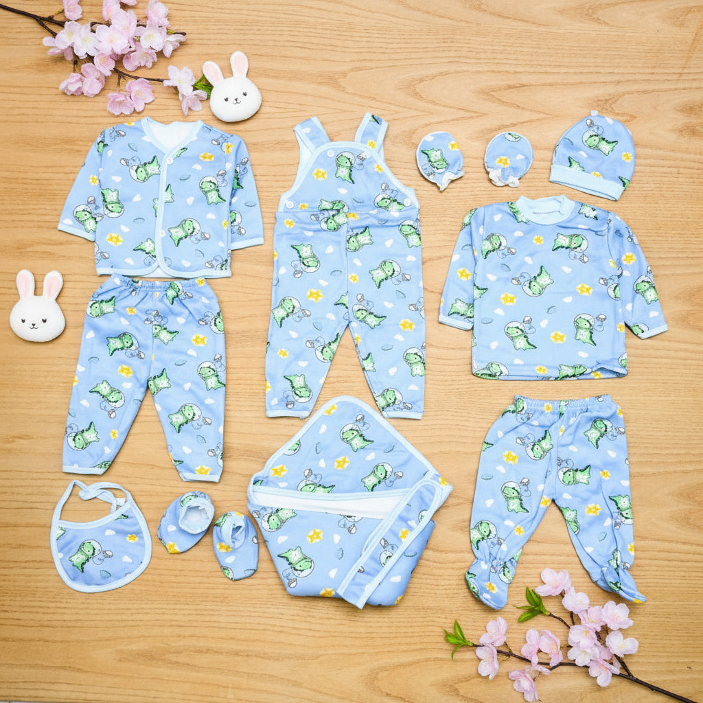 Collection of baby clothing items with frog pattern on a wooden surface