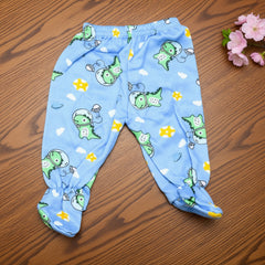 Blue children's pants with green dinosaur pattern on a wooden surface