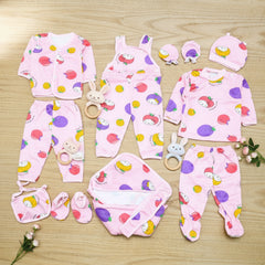 Collection of baby clothing items with colorful patterns on a wooden surface