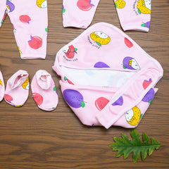 Baby clothing set with hat, diaper, and booties on a wooden surface