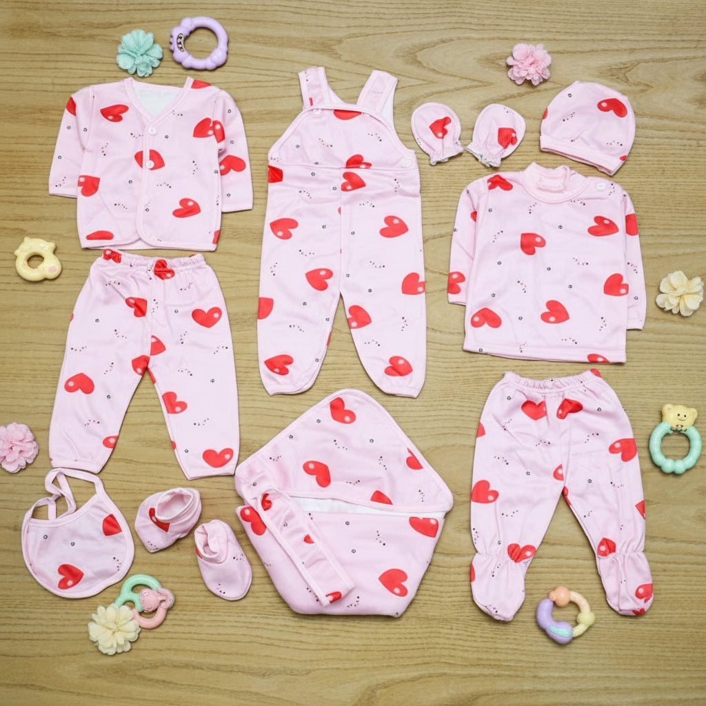 Baby clothing set with red heart patterns on a wooden surface