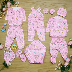 Collection of pink baby clothing and accessories on a wooden surface