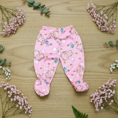 Pink baby pants with bear pattern on a wooden surface