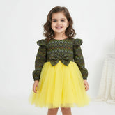 Green patterned top and yellow tutu skirt.