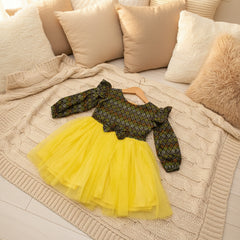 Patterned top and yellow tutu skirt.