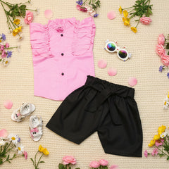 Pink shirt with ruffled details, black shorts