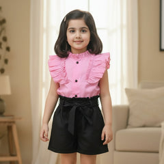 Pink shirt with ruffled details, black shorts