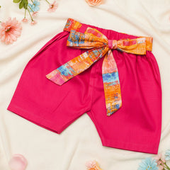 Pink shorts with a colorful belt.