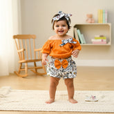 Children's outfit with mustard top, floral shorts, and accessories