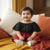 Black crop top with ruffled sleeves, red shorts