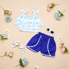 Children's blue shorts with white lace trim, white top with blue floral pattern