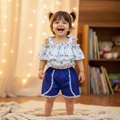 Children's blue shorts with white lace trim, white top with blue floral pattern