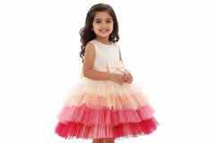 A sleeveless multicolor multilayer knee-length frock with a round neckline and a front bow detail, primarily in shades of peach.