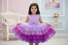 A sleeveless multicolor multilayer knee-length frock with a round neckline and a front bow detail, primarily in shades of purple.