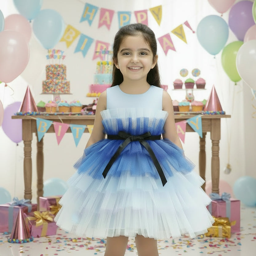 A multicolor multilayer ribbon bow knee-length frock with a round neckline and sleeveless design, predominantly in shades of blue.