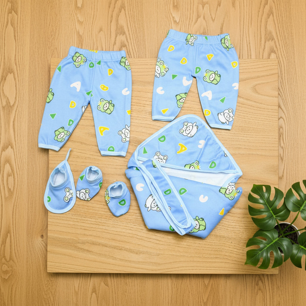 Baby clothing set with pants, shoes, and a blanket on a wooden surface.