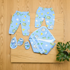 Baby clothing set with pants, shoes, and a blanket on a wooden surface.