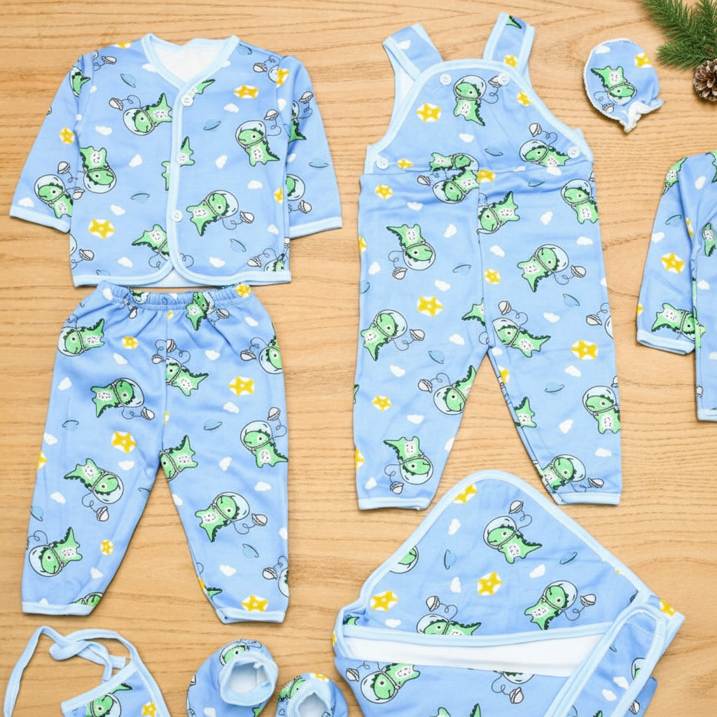 Children's blue pajama set with green frog pattern on a wooden surface
