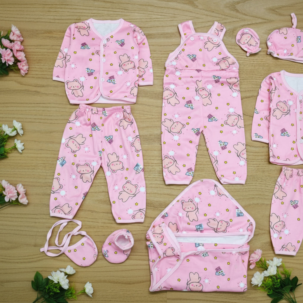 Pink baby outfit set with bear pattern on a wooden surface