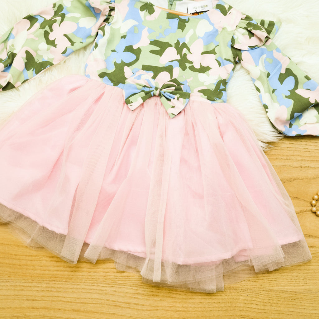 Pink tulle skirt on a wooden surface with floral-patterned fabric