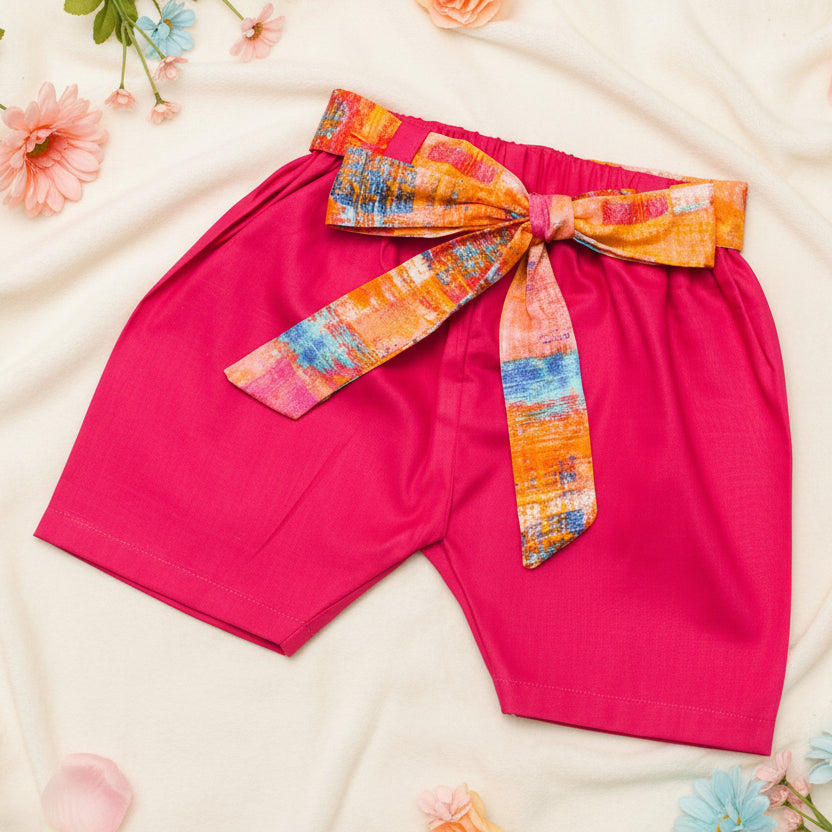 Pink shorts with a colorful belt. 