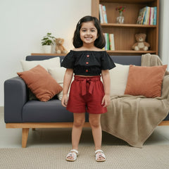 Black crop top with ruffled sleeves, red shorts