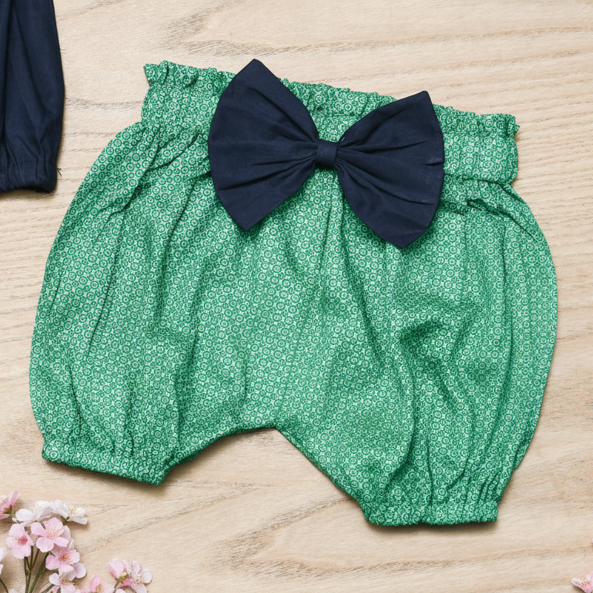 Green baby bloomers with a navy blue bow 