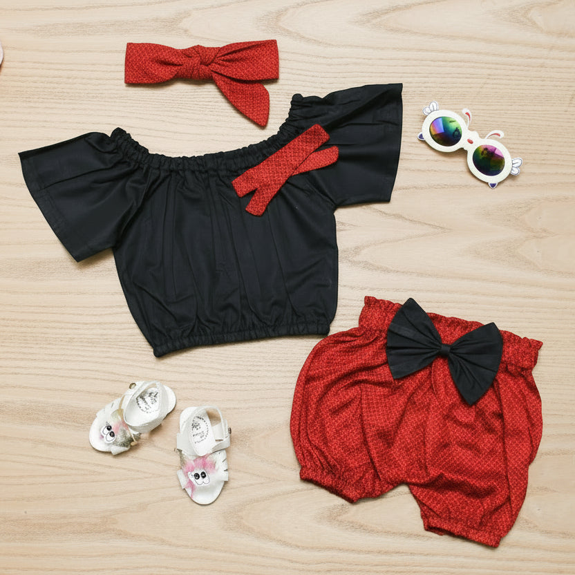 Black top with red bows, red shorts with black bows.